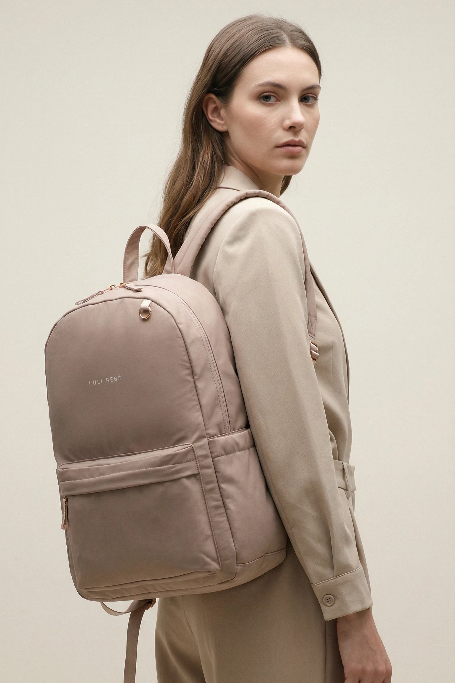 Lifestyle photo of a woman wearing a blush daily backpack – side view showing fit and proportions, minimalist design by Luli Bebé