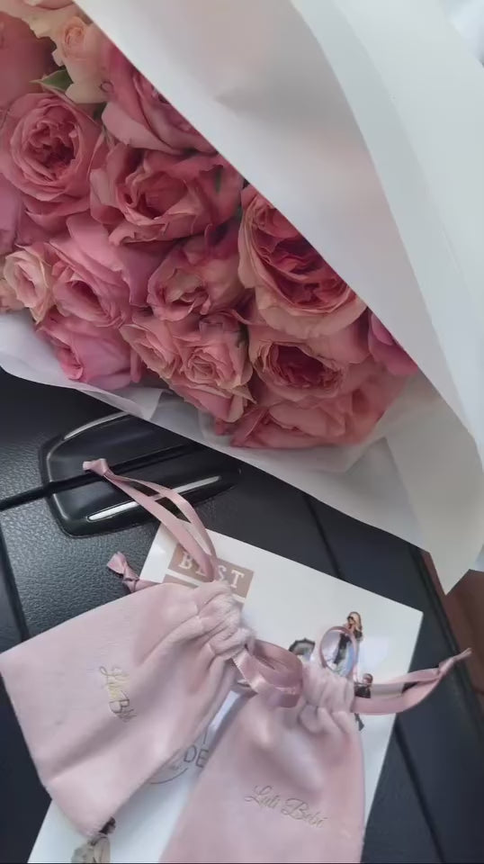 POV-style video of woman driving while wearing the Luli Bebé Mama Necklace, showcasing how it pairs beautifully with everyday outfits on the go.