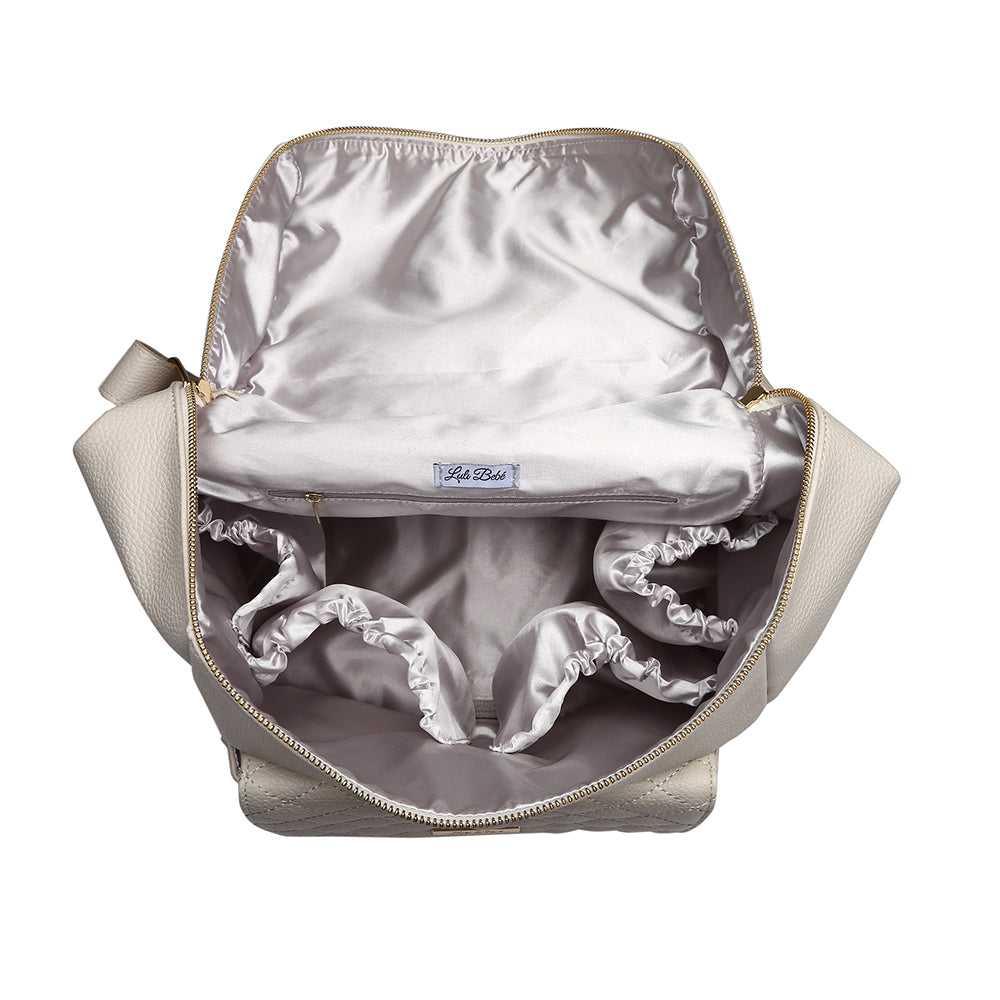 Interior of Luli Bebé Signature Pearl White diaper bag – satin lining with multiple pockets for bottles, wipes, and baby must-haves