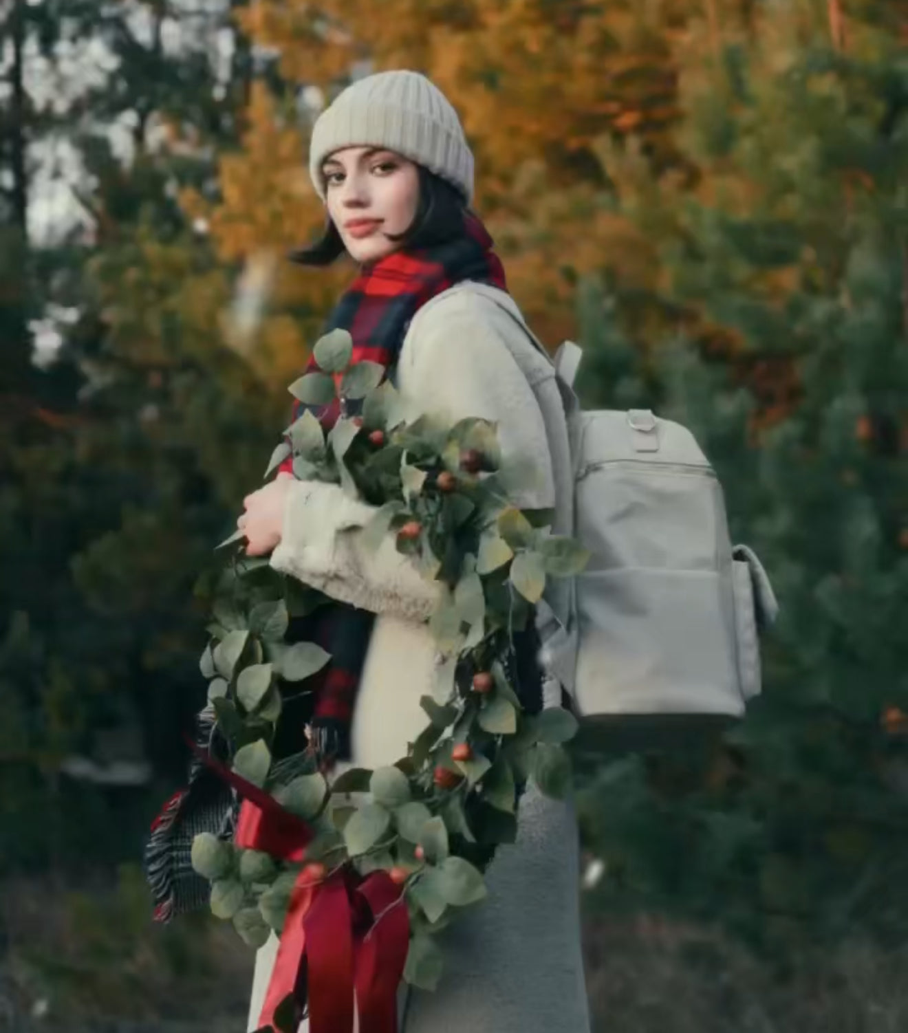 Woman wearing designer diaper bag backpack outdoors in autumn