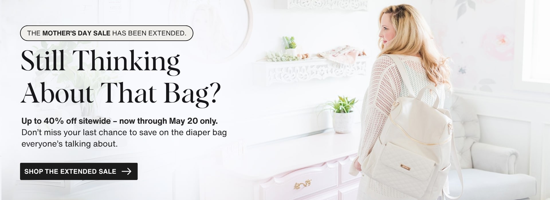 Blonde woman looking over her shoulder wearing a White Pearl Luli Bebé diaper backpack in a bright floral nursery. Banner text promotes “Still Thinking About That Bag? Up to 40% off sitewide – Extended through May 20"
