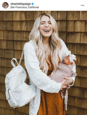 mom carrying diaper bag and baby