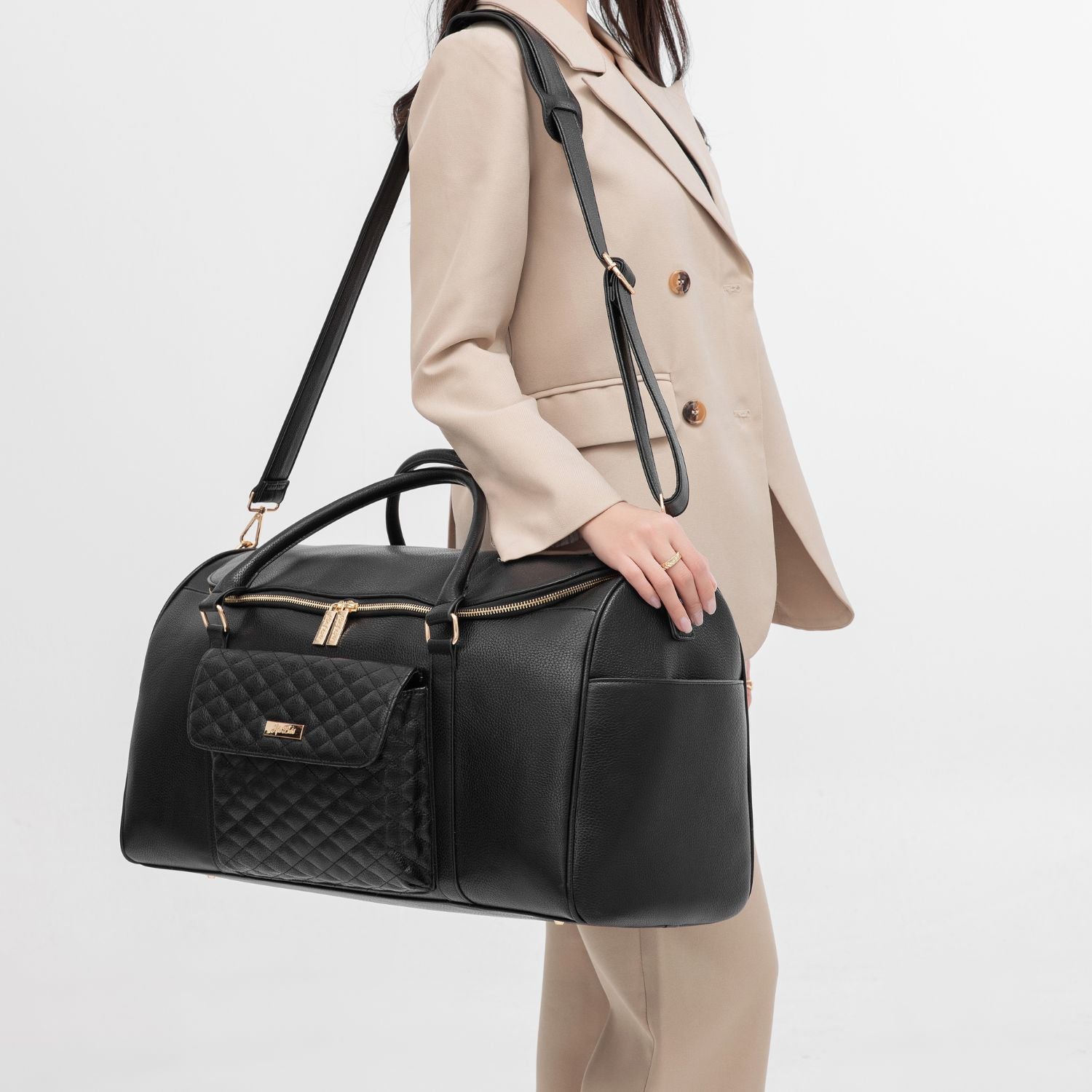 Elegant mom wearing a black Luli Bebé duffel bag, looking chic and travel-ready