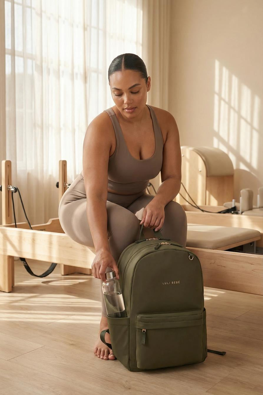 Luli Bebe Daily Backpack in olive color, modern lifestyle image with model using everyday backpack