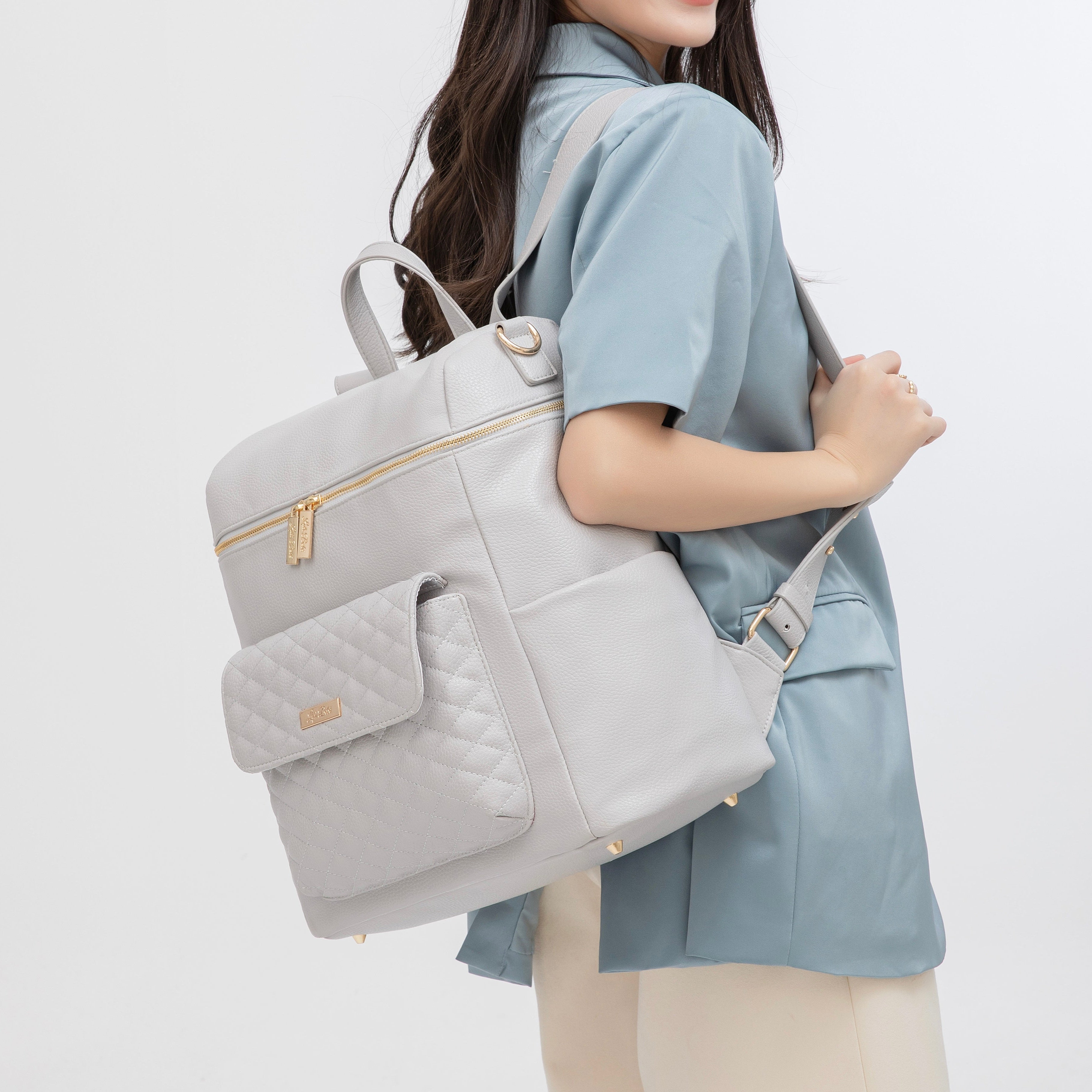 Mom wearing the Signature Luli Bebe diaper bag – stylish backpack look for moms with baby essentials and travel needs.